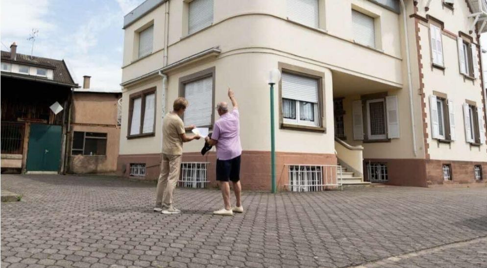 Propriétaire et chargé de mission devant un immeuble à étudier
